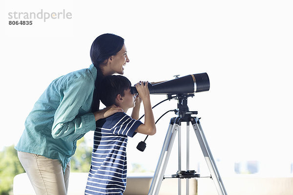 Mutter und Sohn mit Teleskop