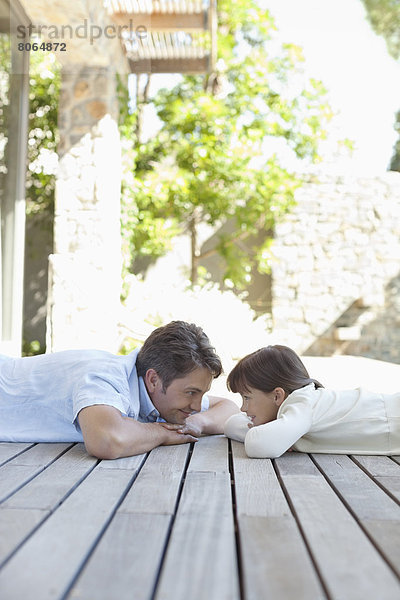 Vater und Tochter auf der Veranda liegend