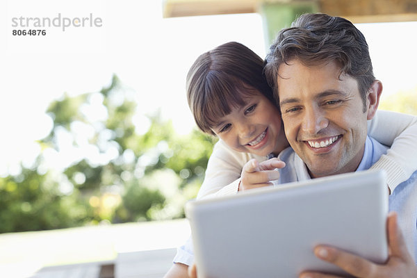 Vater und Tochter nutzen gemeinsam den Tablet-Computer