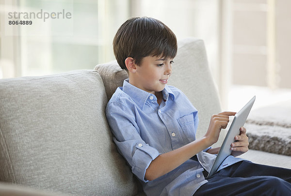 Junge mit Tablet-Computer auf dem Sofa