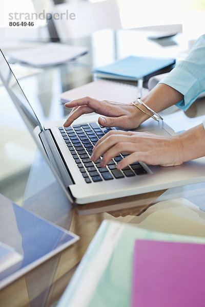 Geschäftsfrau mit Laptop am Schreibtisch