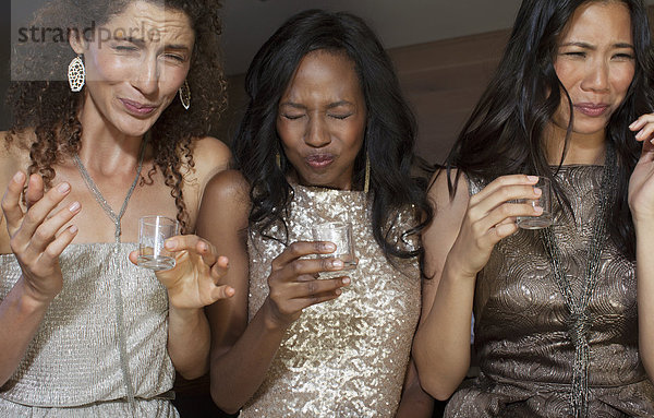 Frauen  die auf der Party einen Drink trinken.