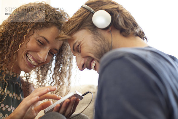 Lächelndes Paar beim Hören von Kopfhörern
