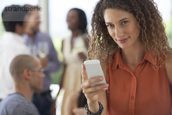 Frau mit Handy auf der Party