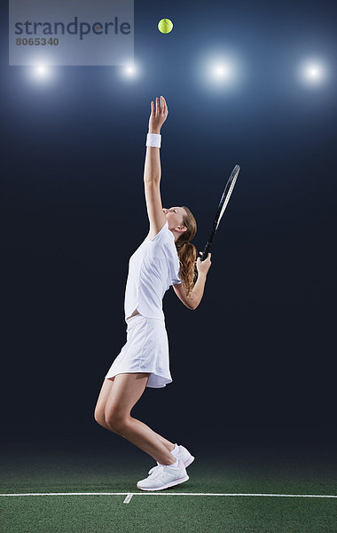 Tennisspieler serviert Ball auf dem Platz