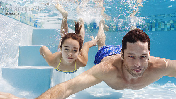 Vater und Tochter schwimmen im Pool