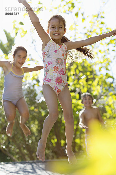 Kinder springen auf Trampolin im Freien