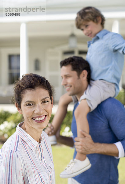 Familie lächelt vor dem Haus