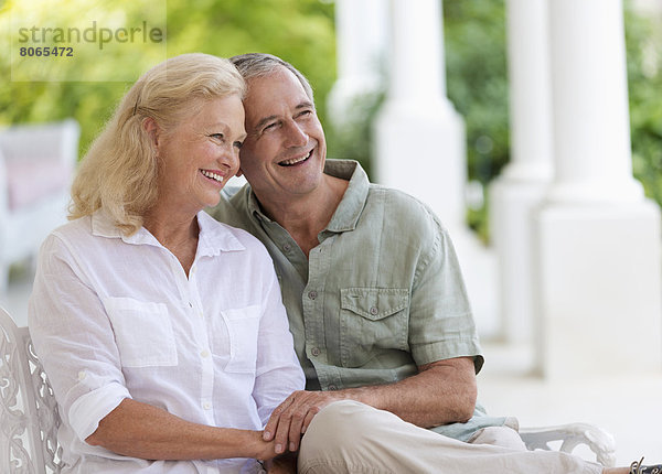 Ältere Paare umarmen sich auf der Veranda