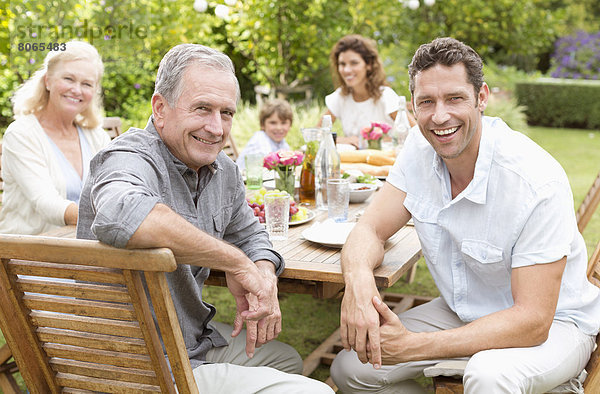 Familie lächelt gemeinsam bei Tisch