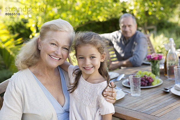 Ältere Frau und Enkelin lächeln im Freien