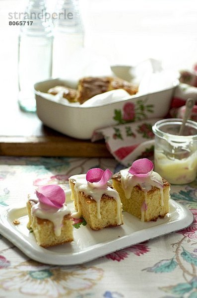 Mandelkuchen mit Rosenblüten und Zuckerguss