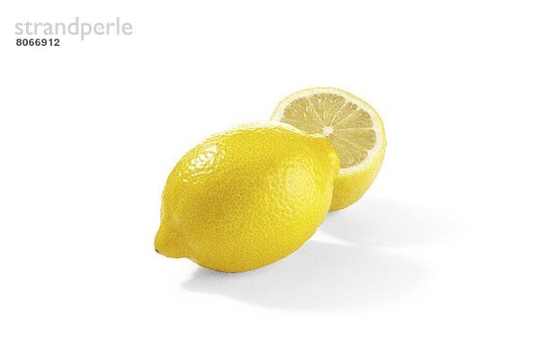 Zitrone und Zitronenhälfte auf weissem Grund