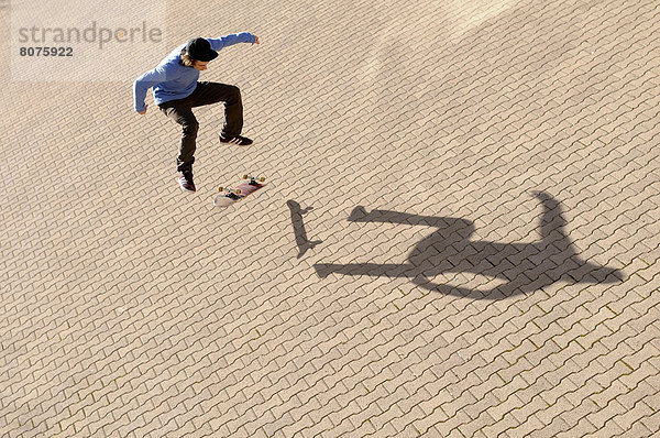Kopfsteinpflaster  Jugendlicher  Straße  Schatten  zeigen  Kunststück  15-16 Jahre  15 bis 16 Jahre  alt  Skateboarding