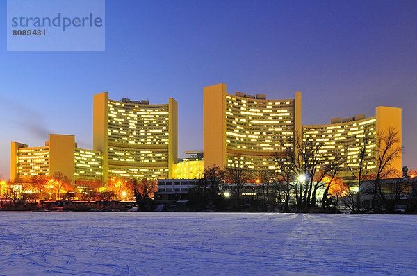 Das Vienna International Centre  Büro der Vereinten Nationen  hinter einem zugefrorenen See in der Abenddämmerung