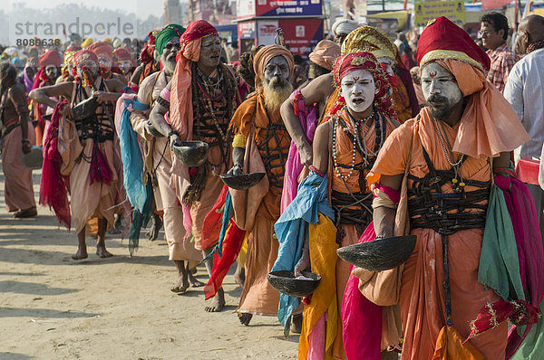 Gruppe von Gudar Sadhus  heilige Männer  zu Fuß in einer Reihe  beim Sammeln von Speisen  die von anderen Sadhus angeboten werden  am Sangam  dem Zusammenfluss von Ganges  Yamuna und Saraswati  während der Kumbh Mela
