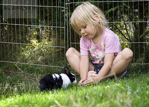 Mädchen  4 Jahre  spielt mit Kaninchen
