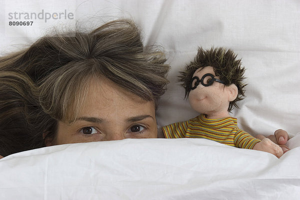 Frau mit Puppe im Bett