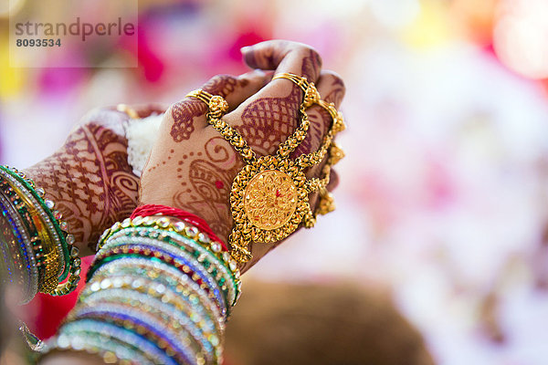 Close up of hands with intricate henna design