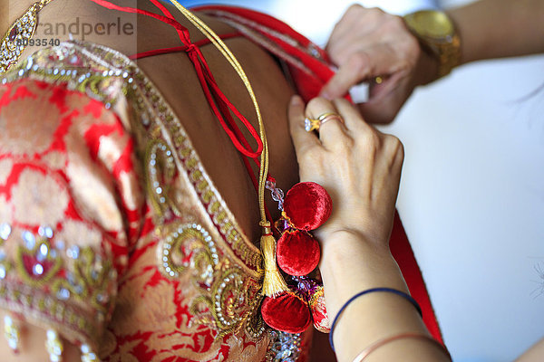 Dressmaker adjusting traditional Indian dress