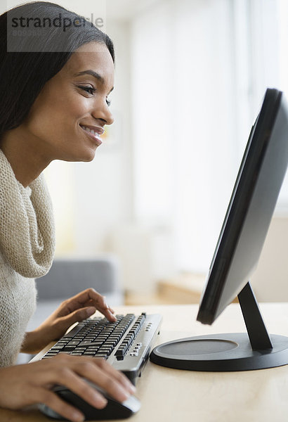 Mixed race woman using computer