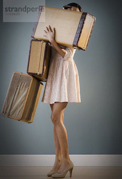 Mixed race woman carrying suitcases