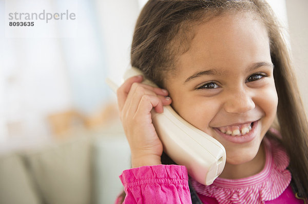 Hispanic girl talking on telephone