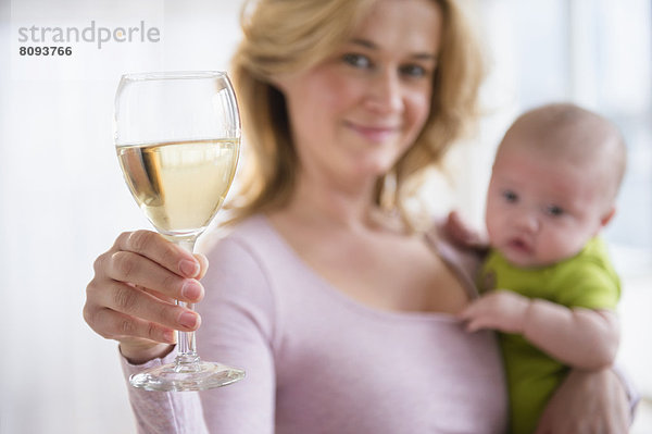 Caucasian mother with baby having glass of wine