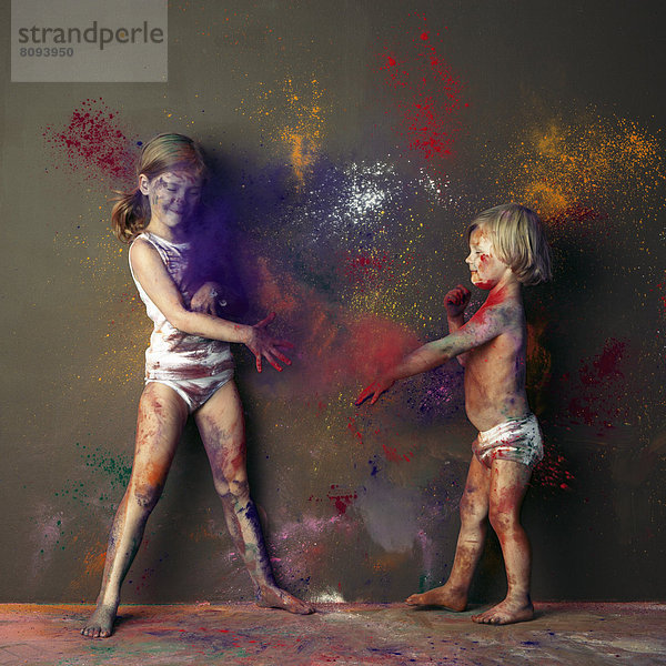 Caucasian children playing with paint