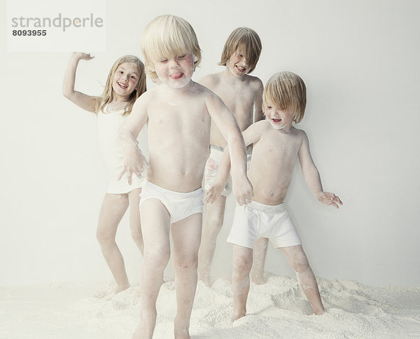 Caucasian children playing in flour