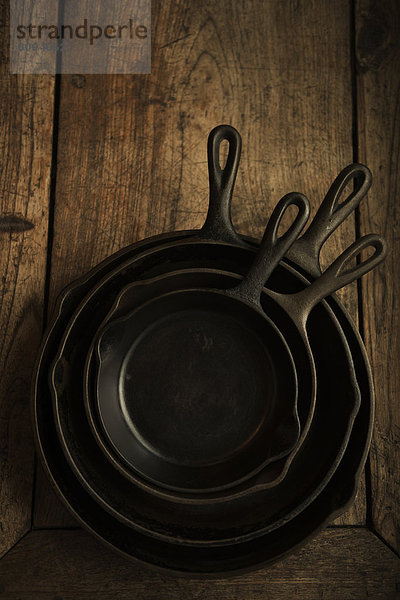 Empty cast iron pans on wooden board