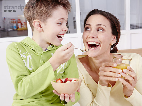 Mutter und Sohn essen frisches Obst und Müsli