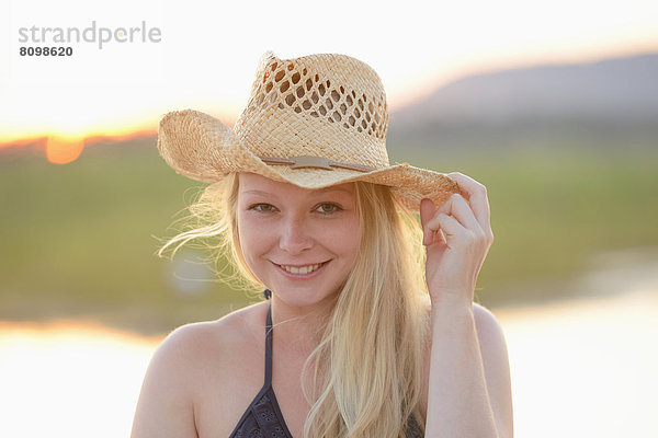 Junge Frau im Bikini mit Strohhut Portrait