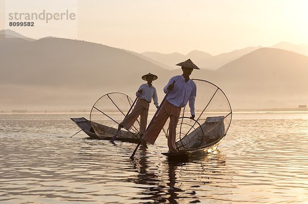 kegelförmig Kegel benutzen Gehhilfe Fisch Pisces Tradition Sonnenuntergang über strecken See Netz Rudern Fischer Bambus Südostasien Myanmar Inle See