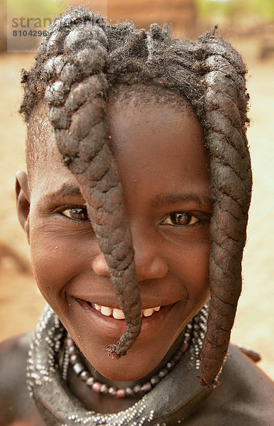 Lächelndes Himba-Mädchen mit typischer Haartracht