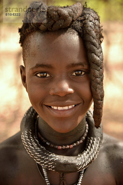 Lächelndes Himba-Mädchen mit typischer Haartracht