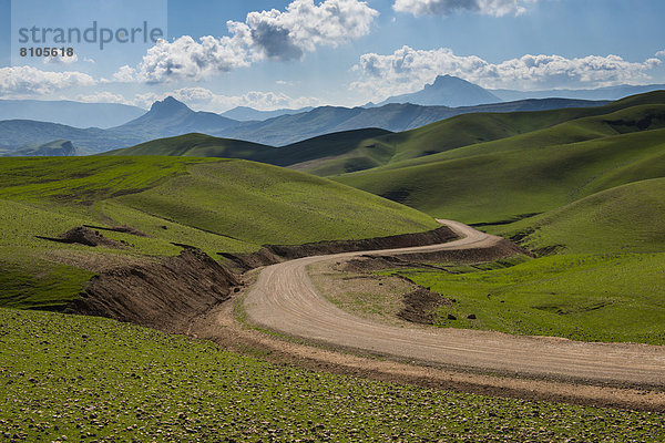 Straße windet sich durch die grüne Hügellandschaft  an der Grenze zum Iran