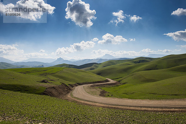 Straße windet sich durch die grüne Hügellandschaft  an der Grenze zum Iran