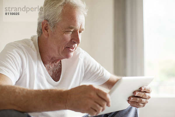 Älterer Mann mit digitaler Tablette