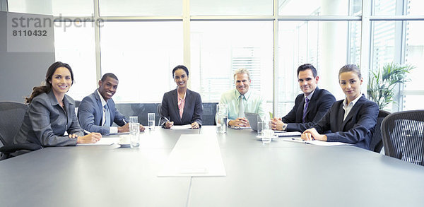 Portrait von selbstbewussten Geschäftsleuten am Tisch im Konferenzraum