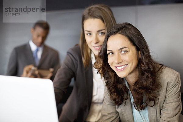 Portrait von lächelnden Geschäftsfrauen mit Laptop
