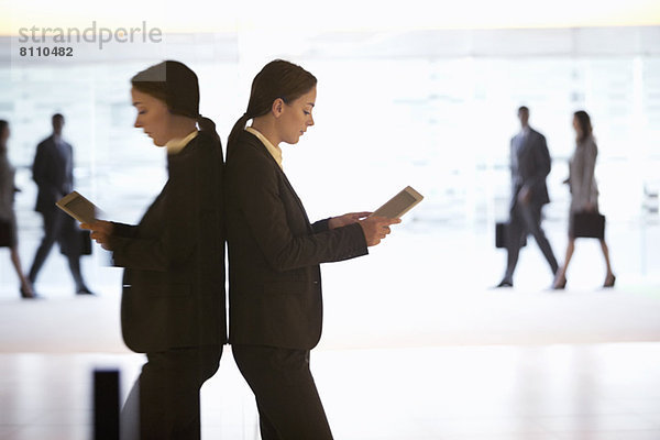 Geschäftsfrau mit digitalem Tablett in der Lobby