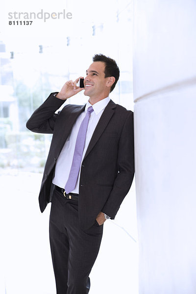Lächelnder Geschäftsmann im Gespräch mit dem Handy