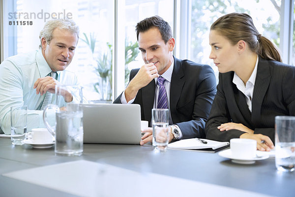 Business-Leute teilen Laptop in der Sitzung