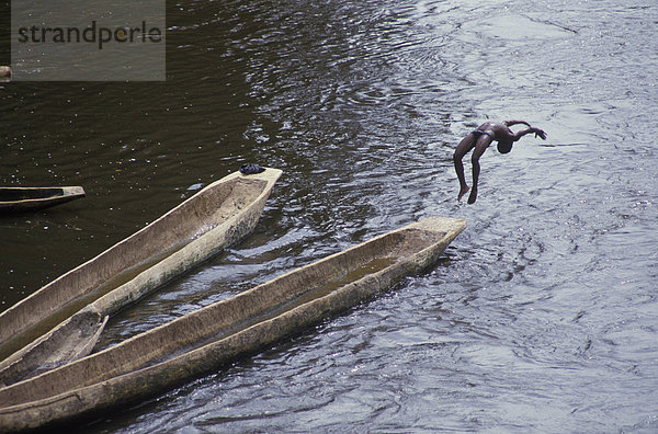 Außenaufnahme  Einzelperson  eine Person  Wasser  Farbaufnahme  Farbe  Abenteuer  Abend  Mut  Athlet  See  Querformat  Fluss  Herausforderung  Kanu  3  Fotografie  Seitenansicht  Akrobat  Junge - Person  Afrika  Spaß  In der Luft schwebend  freie Natur  Überschlag