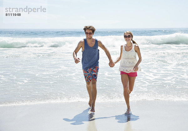 Glückliches Paar am Strand unterwegs
