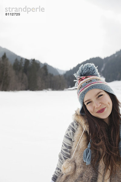 Porträt einer lächelnden Frau im Schneefeld