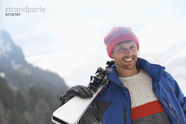 Porträt eines lächelnden Mannes mit Skiern