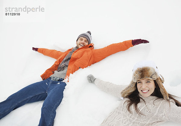 Porträt des glücklichen Paares  das Schnee-Engel macht