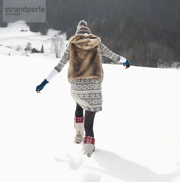 Frau beim Wandern im verschneiten Feld